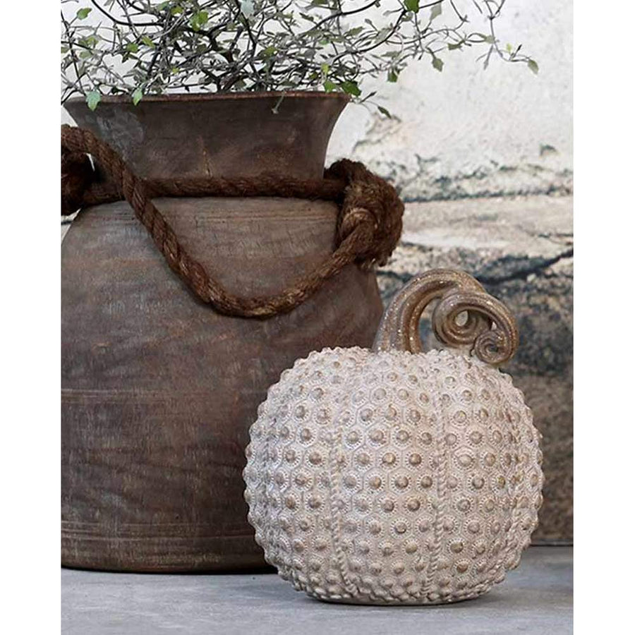 Dombormintás felületű,, antik arany latte színű vintage stílusú dísztök dekoráció romos fal előtt, barna vázával.