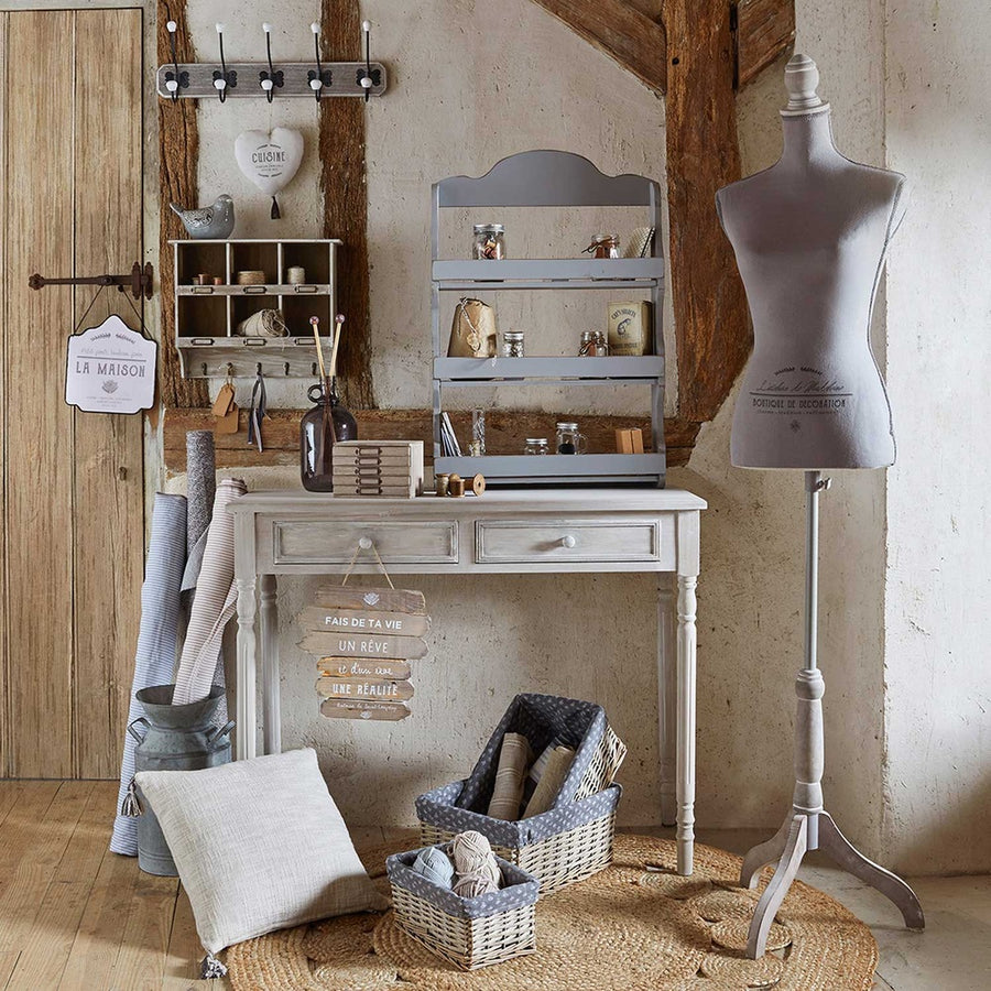 Vintage falifogas, vidéki nappaliban, próbababával, íróasztallal és kosarakkal. 