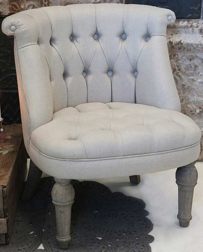 Francia stílusú vintage fotel masszív tölgyfa lábakkal, ekrü színű, gombbehúzásos technikával díszített tűzálló pamutvászon kárpittal nappaliban 