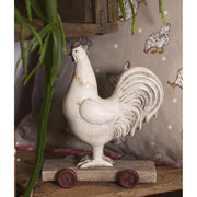 Vidéki vintage stílusú, 15 cm hosszú és 17 cm magas, kiskocsin álló nosztalgikus kakas figura..