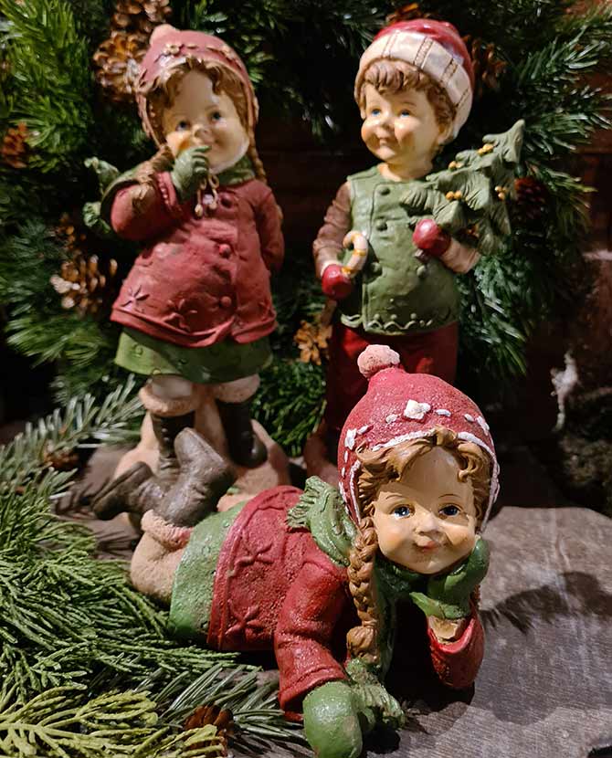 Vintage karácsonyi téli kisfiú és kislány zöld fenyő előtt