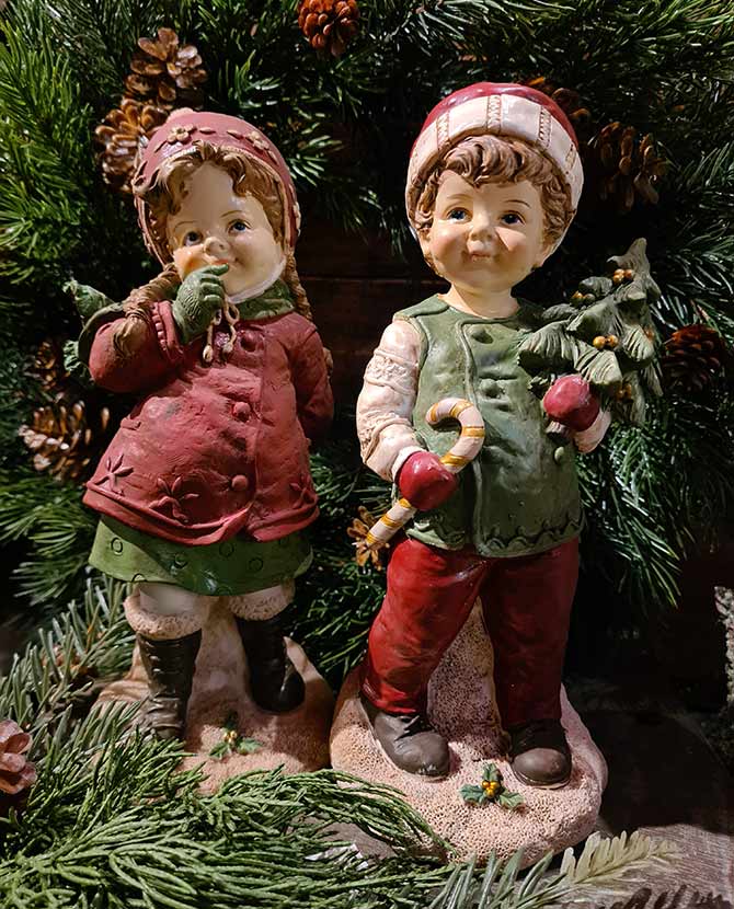 Vintage karácsonyi kislány és kisfiú zöld fenyőfa előtt