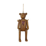 Vintage stílusú, 10 cm magas, függeszthető kialakítású, barna színű, fa hatású maci figura.