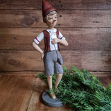 Vintage stílusú, tarisznyát viselő Pinokkió-figura.