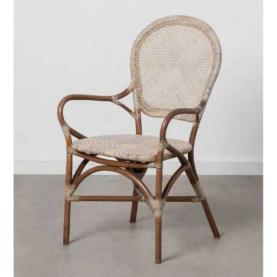 Vintage stílusú, természetes rattanból készült, bézs és barna színű kézműves karosszék, szürke színű fal előtt.