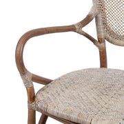 Vintage stílusú, természetes rattanból készült, bézs és barna színű kézműves karosszék karfája.
