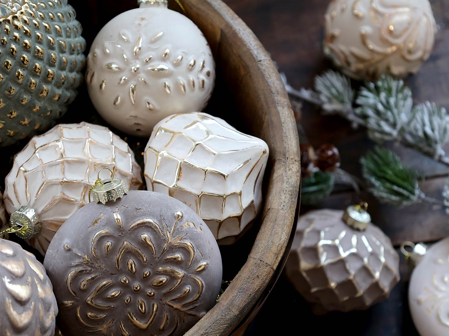 Aranyszínű dombormintával díszített, vintage karácsonyfadíszek fa tálban..