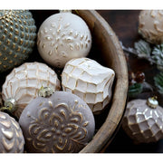 Aranyszínű dombormintával díszített, vintage karácsonyfadíszek fa tálban..