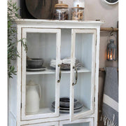 Vintage stílusú, antik krém színű vitrines szekrény nyitott ajtaja.