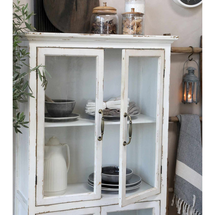 Vintage stílusú, antik krém színű vitrines szekrény nyitott ajtaja.